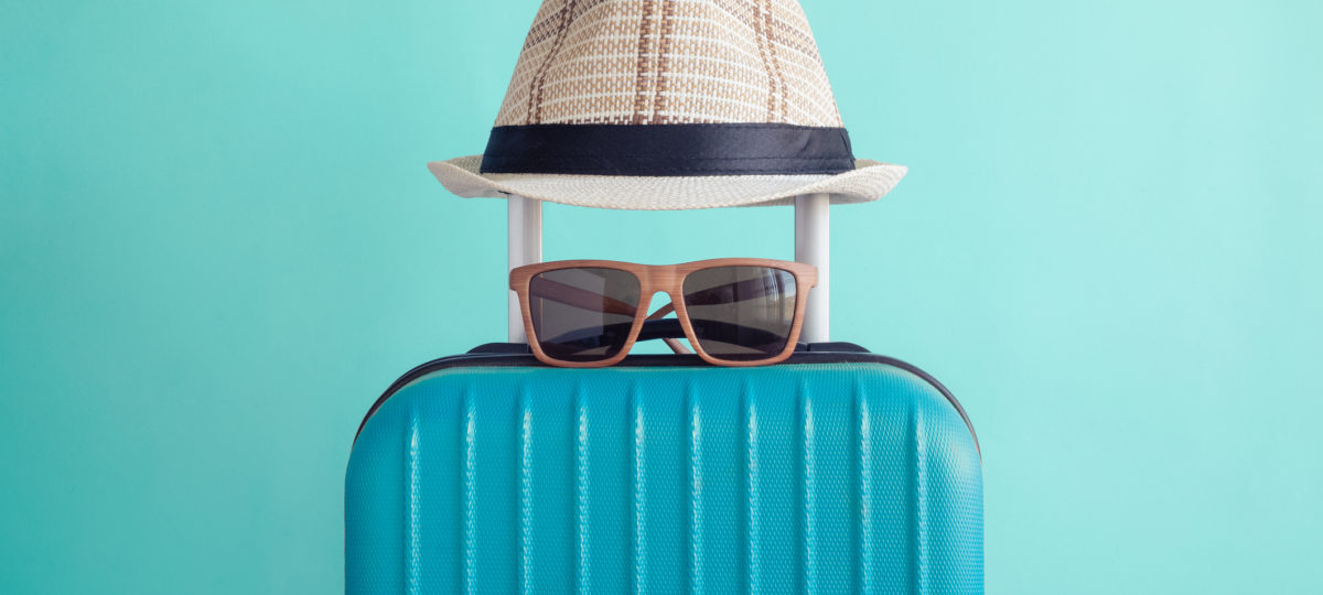 Okulary i kapelusz na walizce